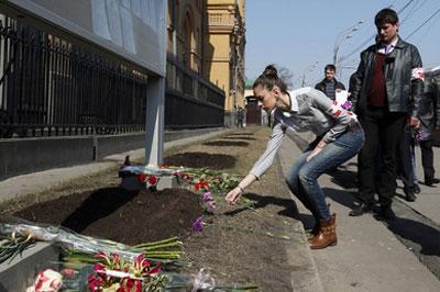 В Москве люди несут цветы к посольству Украины